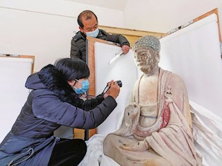大足石刻研究院的工作人员正在对将要运往国家一级博物馆苏州博物馆展出的馆藏文物进行检查装箱