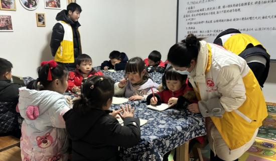 志愿者辅导学生做作业。 （回龙镇供图）