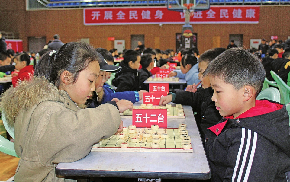 　　左图：12月28日，400余名棋手集聚区体育中心参加第五届少儿围棋象棋比赛暨定段定级赛。
　　记者张玮摄
