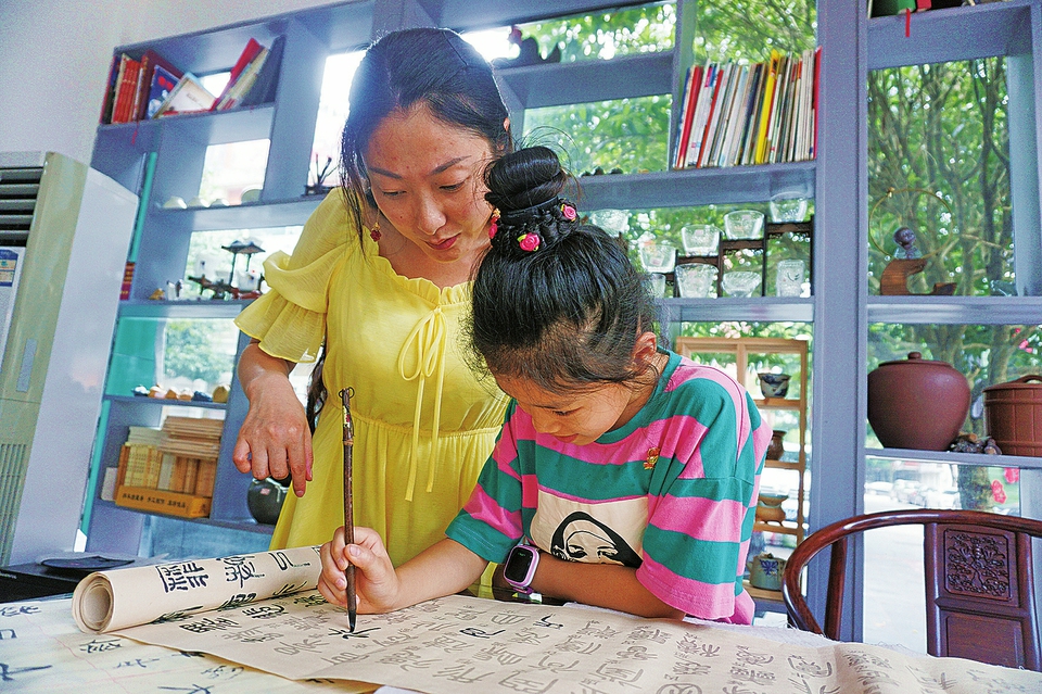 　　昨日，在宏声文化广场“千手禅茶”妇女儿童活动室，一名儿童在跟随书法老师练习书法。暑期，广大少年儿童在玩耍之余，不忘学习琴棋书画、游泳、武术等各类才艺，让自己掌握一门受益终身的艺体特长。 记者邓小强摄
