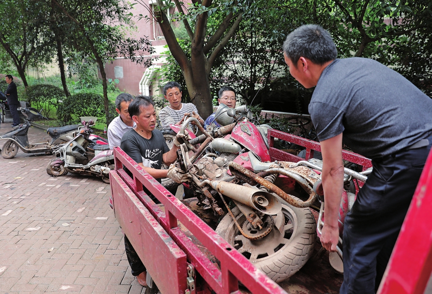 　　近日，搬运工人正在清理五星华府小区内的僵尸车。当日，棠香街道联合小区物管公司开展创卫行动，对小区内废弃的30余辆自行车和20余辆电动摩托车进行集中清理，让小区环境变得更加整洁。
　　记者黄舒 通讯员孙怡摄
